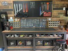 an organized workbench in a garage with lots of tools hanging on the wall