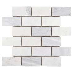 white marble brick wall tiles with grey and beige stripes on the bottom, in an angled pattern