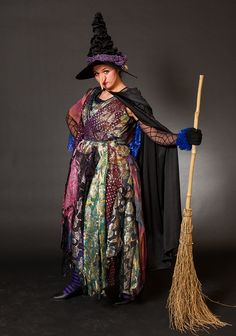 a woman dressed as a witch holding a broom