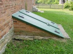 an upside down green case sitting on top of a brick wall next to a grass field