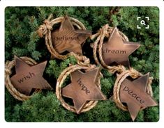 five brown star ornaments with words on them