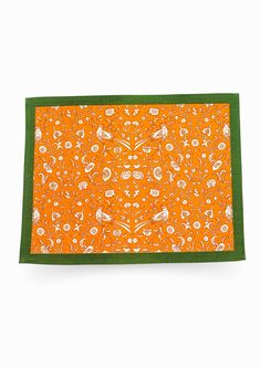 an orange and green placemat with white flowers on it