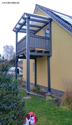 a yellow house with a deck and stairs