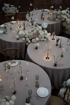 the tables are set with white flowers and candles