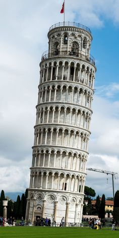 a very tall tower with a flag on it's top in the middle of a field