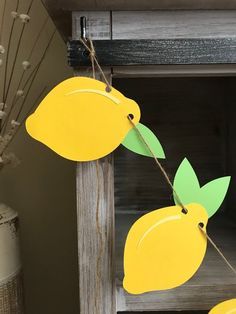 some paper lemons are hanging from a string