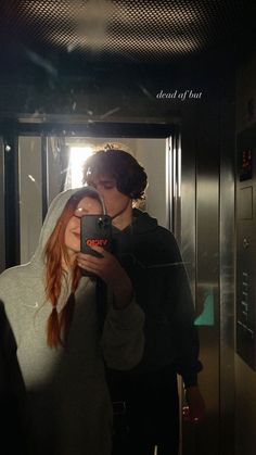 a man and woman are taking a selfie in the mirror while standing next to each other