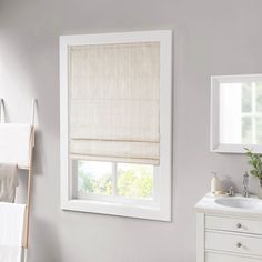 a bathroom with a sink, window and towel rack