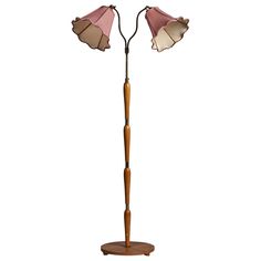 a wooden floor lamp with two pink shades