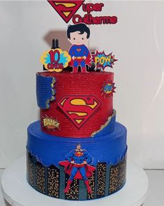 a three tiered cake decorated with supermans and pop culture stickers on top