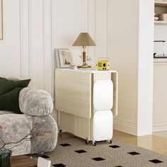 a living room filled with furniture and a white table next to a gray couch on top of a hard wood floor