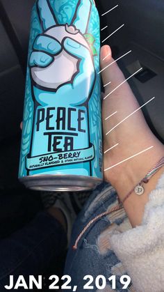 a person holding up a can of peace tea