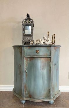 an old blue cabinet with shells on top