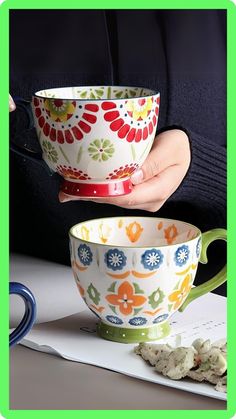 a woman is holding a colorful bowl over a cup