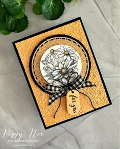 a close up of a card with flowers on it and a plant in the background