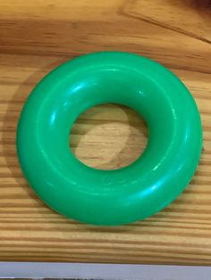 a green ring sitting on top of a wooden table