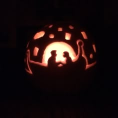 a carved pumpkin with the silhouettes of two people in it