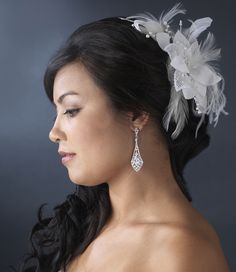 a woman wearing a white flower and feather headpiece