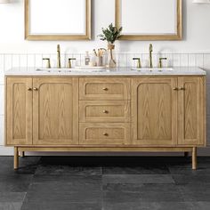 a bathroom with two sinks and mirrors on the wall