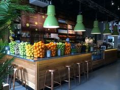 a fruit stand with lots of oranges and other fruits on the counter in front of it