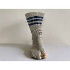 a white and blue striped sock sitting on top of a table next to a wall