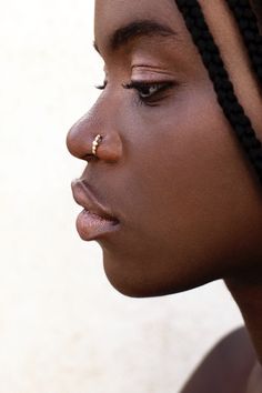 a woman with braids and nose piercing