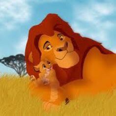 the lion and cub are laying in the grass