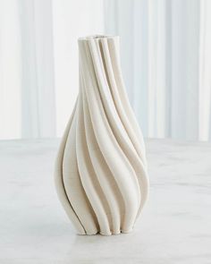 a white vase sitting on top of a table