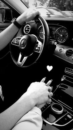 a woman driving a car with her hands on the steering wheel