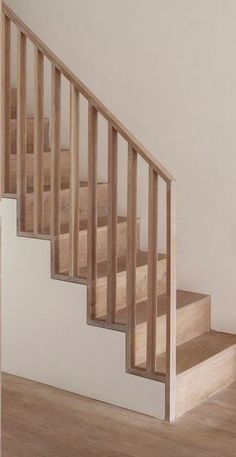 an empty room with wooden stairs and hard wood flooring