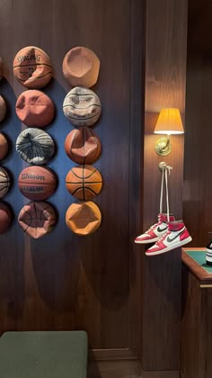 there are many basketballs hanging on the wall next to a green chair and lamp