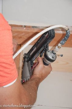 a man is working on an electrical outlet in the wall with a drill and screwdriver