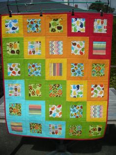 a colorful quilt hanging on a clothes rack