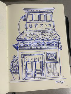 an open notebook with a drawing of a building