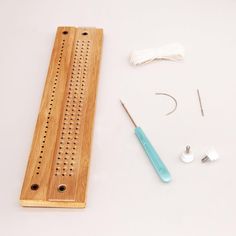 the tools needed to make this wooden peg board are laid out on a white surface