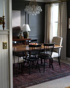 a dinning room table with chairs and a chandelier hanging from the ceiling