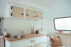 a kitchen area with sink, cabinets and window