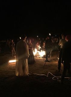 people standing around with torches in the dark