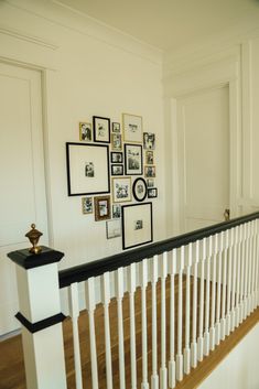 a white staircase with pictures on the wall