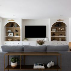 a living room filled with furniture and a flat screen tv mounted to the side of a wall