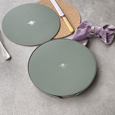 two round trays sitting on top of a table next to a fork and knife