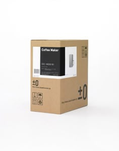 a coffee maker in a cardboard box on a white background