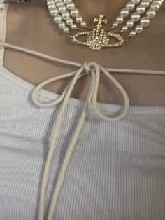 a close up of a person wearing pearls and necklaces