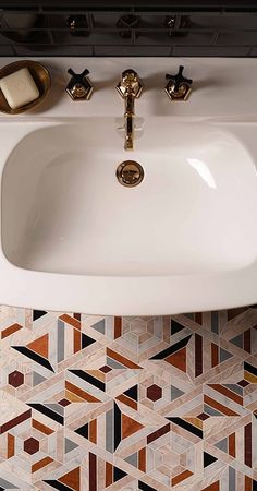 a white sink sitting under a faucet on top of a bathroom counter next to a tiled floor