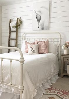 a white bed with pink and white pillows