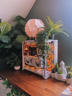 there is a small white clock on the table next to some plants and potted plants