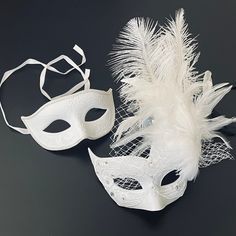 Simplistic for the man in the white rhinestones mask and chic for the woman in the white feather mask. The woman's fabricated texture and lacing veil are destined to pop out at any event. This masquerade mask is great for any occasion. Elegant White Masquerade Mask For Weddings, Elegant White Wedding Masquerade Mask, White Wedding Eye Mask, White Eye Mask For Wedding, White Mask Design, White Feather Mask, Blue Masquerade Mask, Vienna Opera Ball, Mask Couple