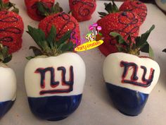 some strawberries are decorated to look like new york giants footballs