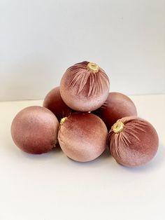 five red onions sitting on top of each other in front of a white wall with gold trim