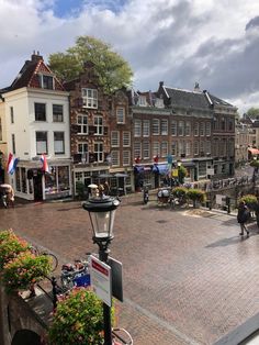 people are walking down the street in an old european town with cobblestone streets